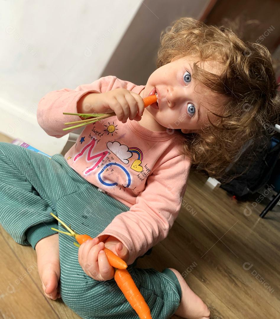 linda menina comendo cenouras..