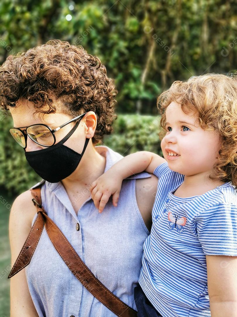 Mãe brasileira usando máscara cuidando da filha em quarentena..