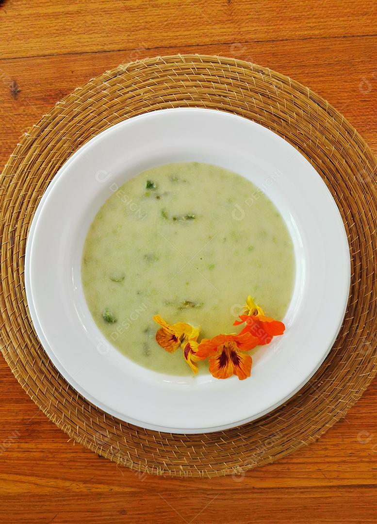 Vista superior da sopa verde com flores comestíveis..