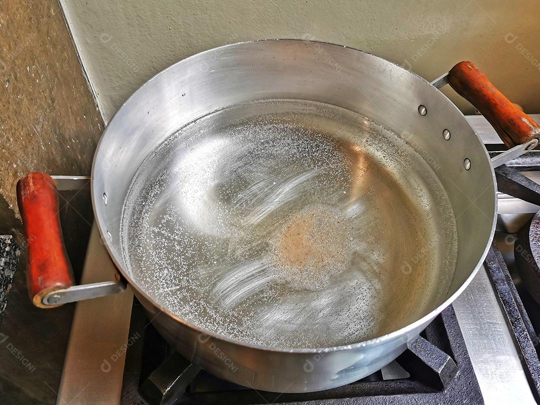 panela grande de alumínio com água fervente.