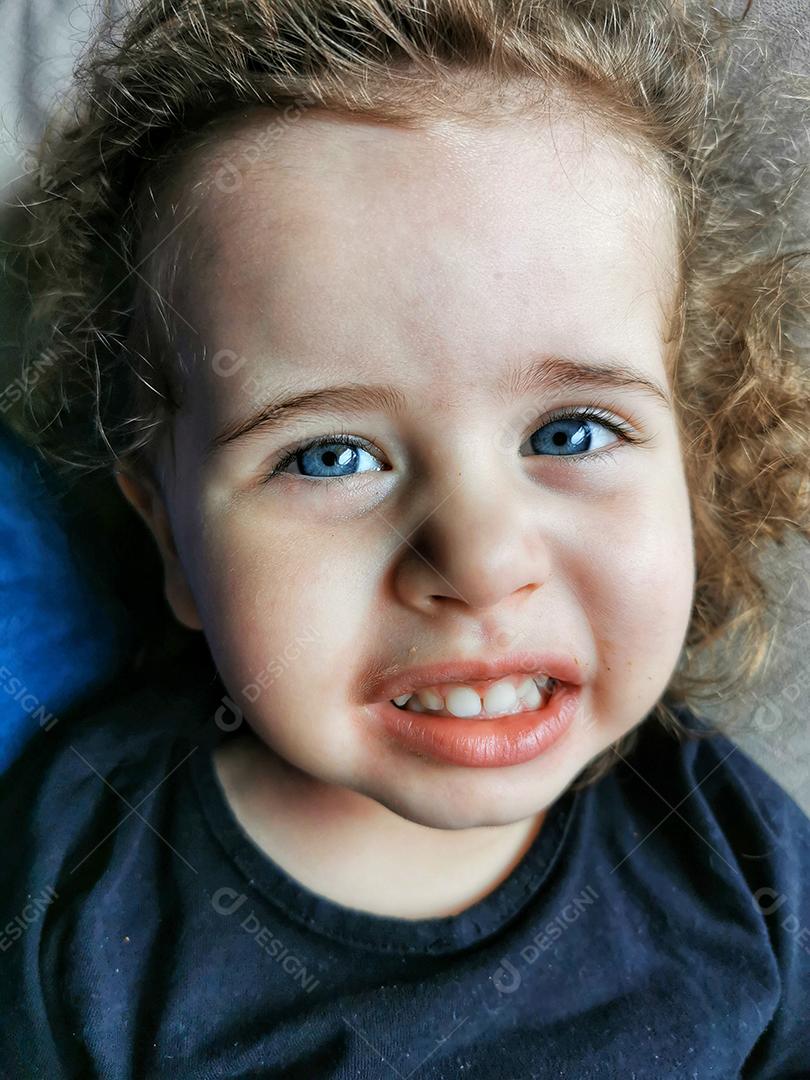 Retrato de uma menina sorrindo e olhando para a câmera.