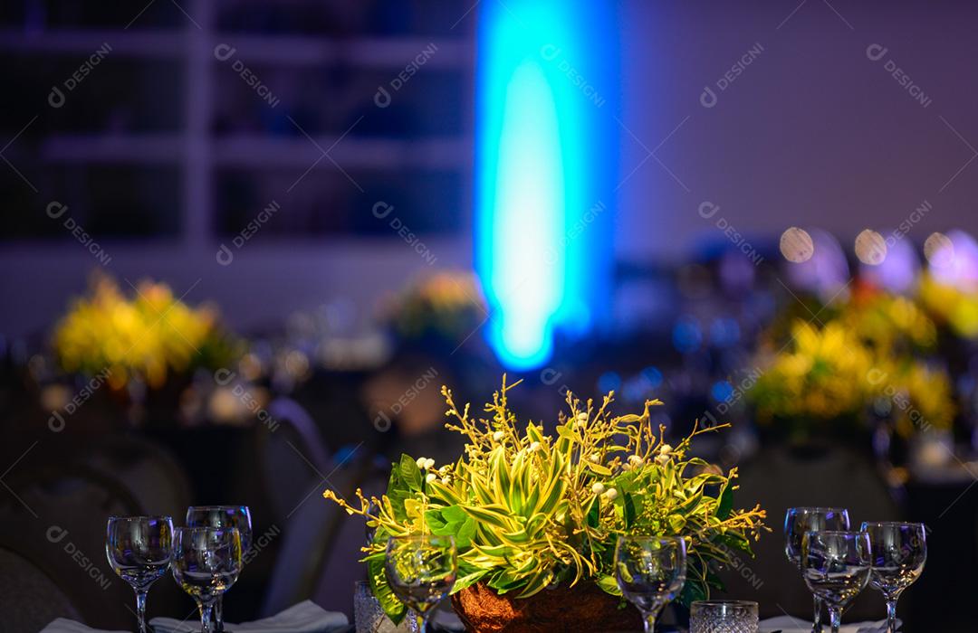 mesa em um salao de festa todo iluminado e com centro de mesa