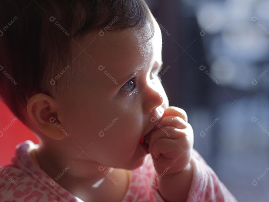 bebê de olhos azuis comendo um pedaço de pão.