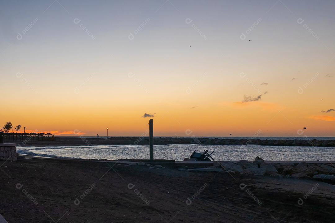vista para o mar e pedras na Praia do Pedregalejo ao entardecer.