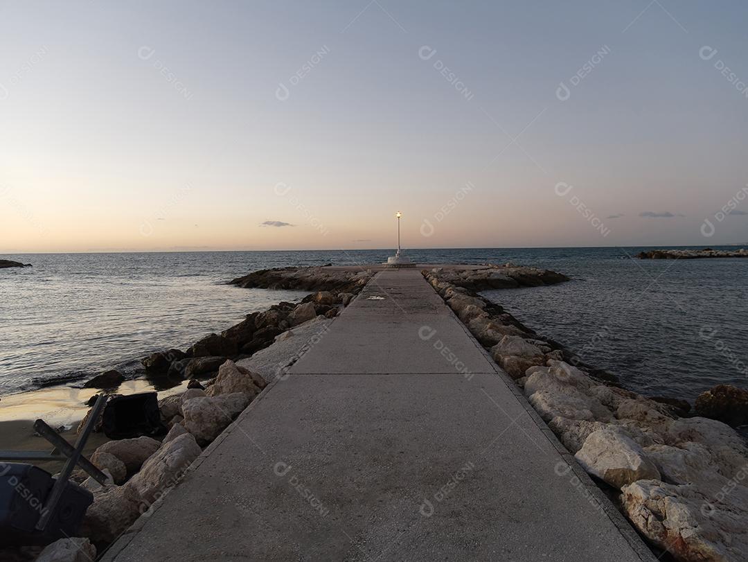 Vista de mar e poste de luz na praia de Pedregalejo ao entardecer.
