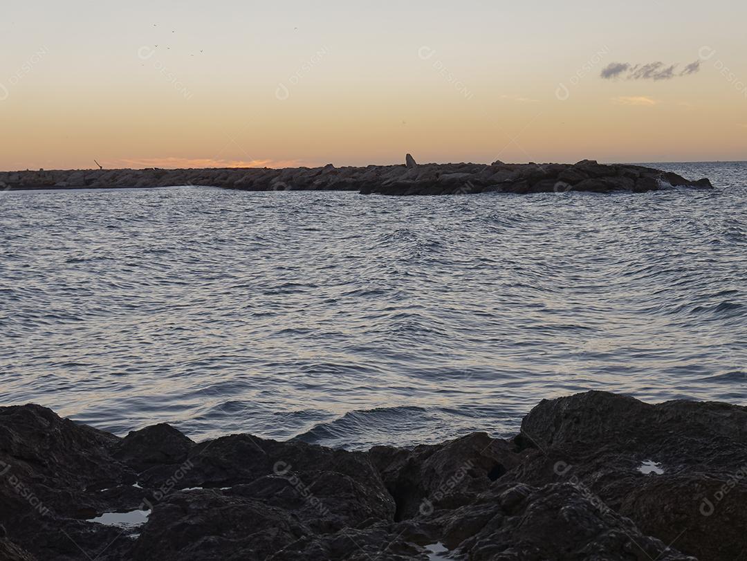 vista para o mar e pedras na Praia do Pedregalejo ao entardecer.