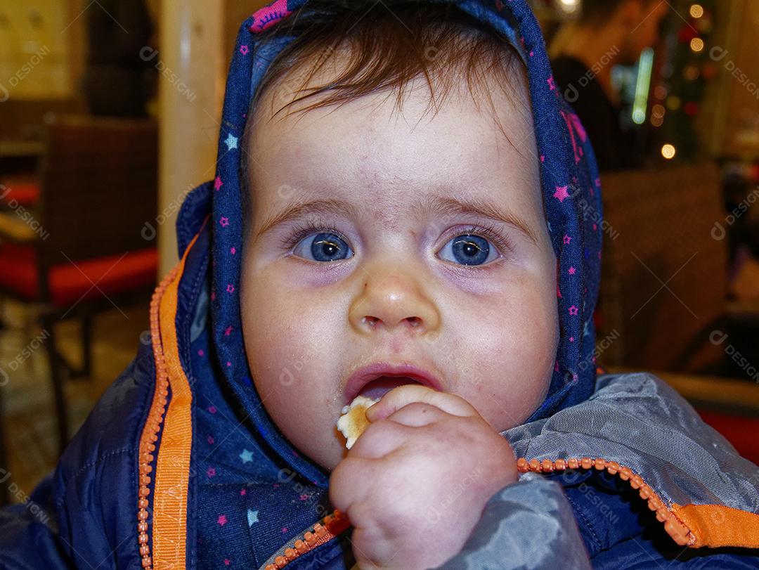 bebê com olhos azuis, olhando para o lado.