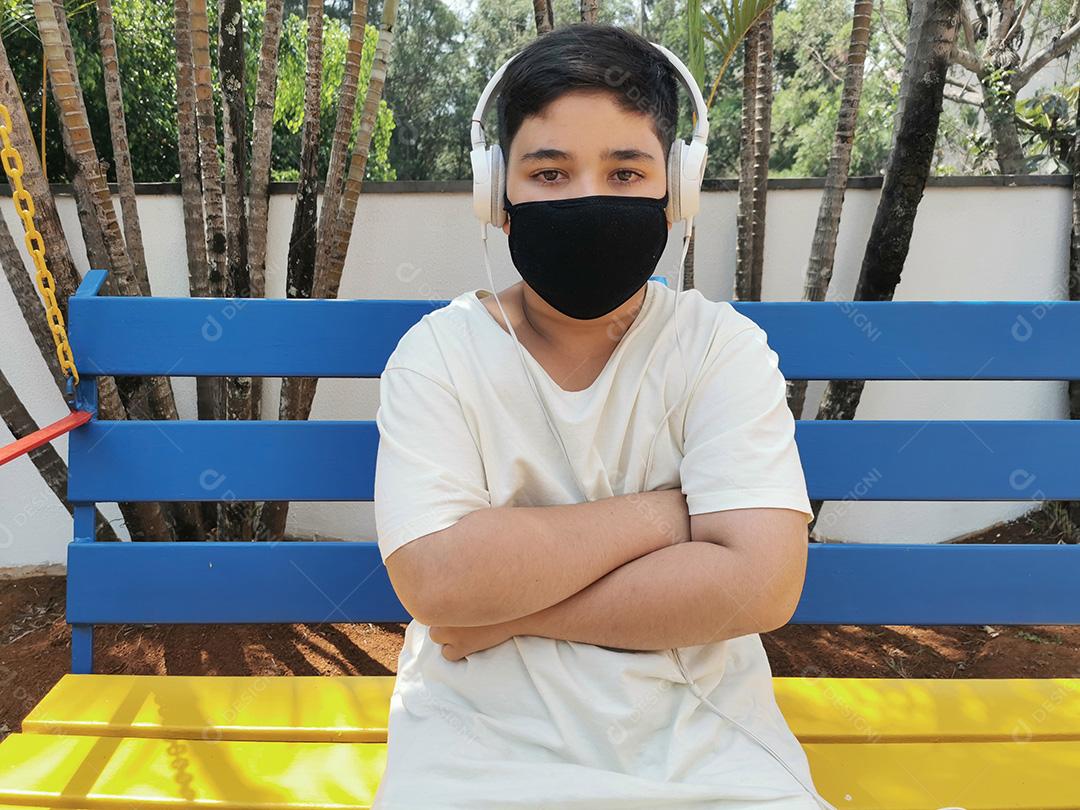 Brazilian boy wearing mask and headphones posing for camera