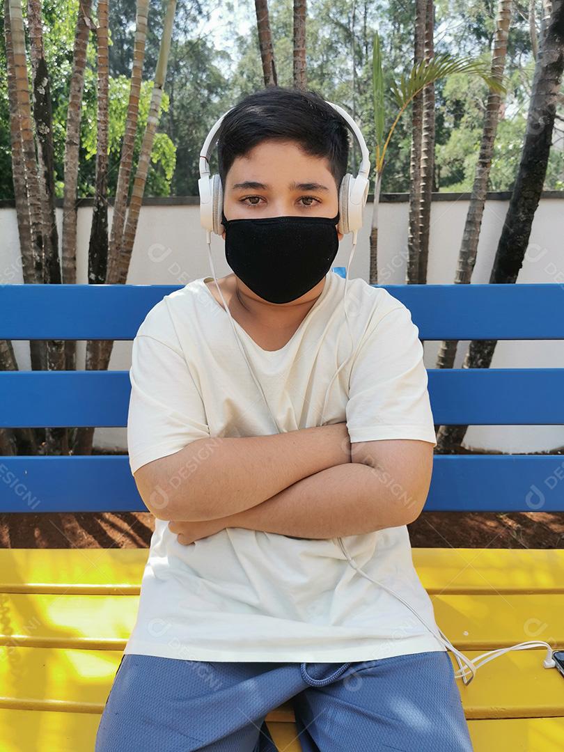 Menino brasileiro usando máscara e fones de ouvido posando para a câmera