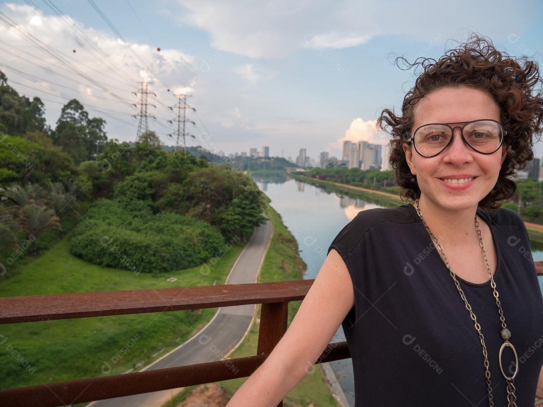 Linda mulher brasileira posando para a câmera com rio ao fundo