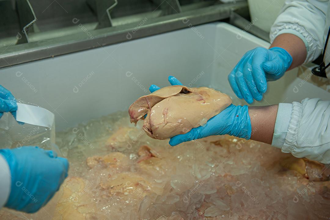 Funcionários limpando e manuseando a carne mais nobre do pato