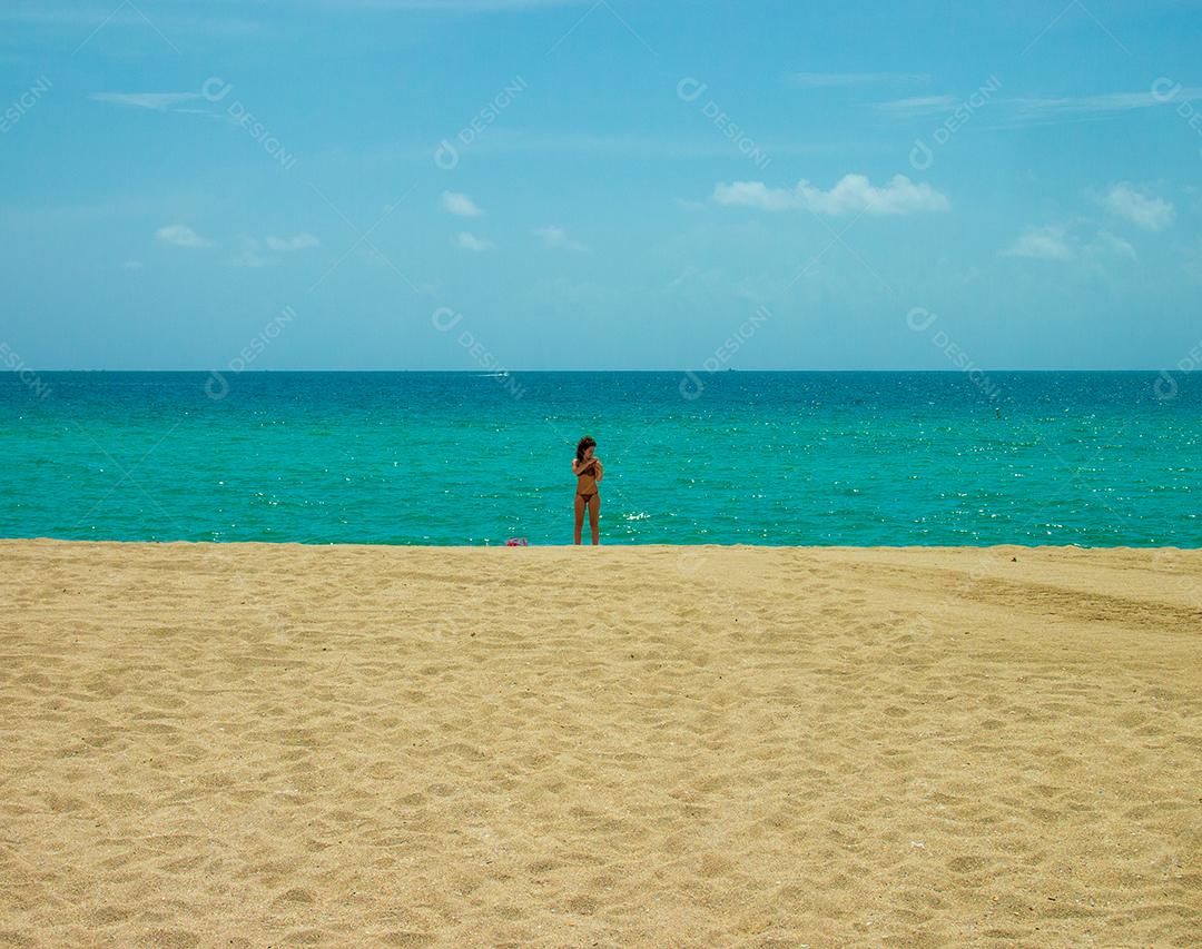 Vista do céu, mar e areia na praia de Miami com uma linda mulher no centro