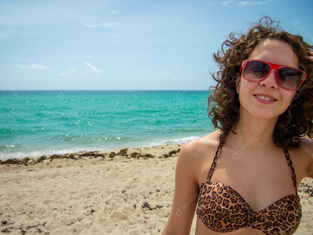 Linda mulher brasileira posando para câmera em Praia de Miami.