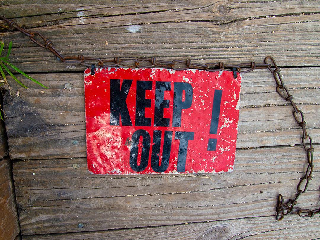 Vista superior do sinal vintage Keep Out no deck de madeira.