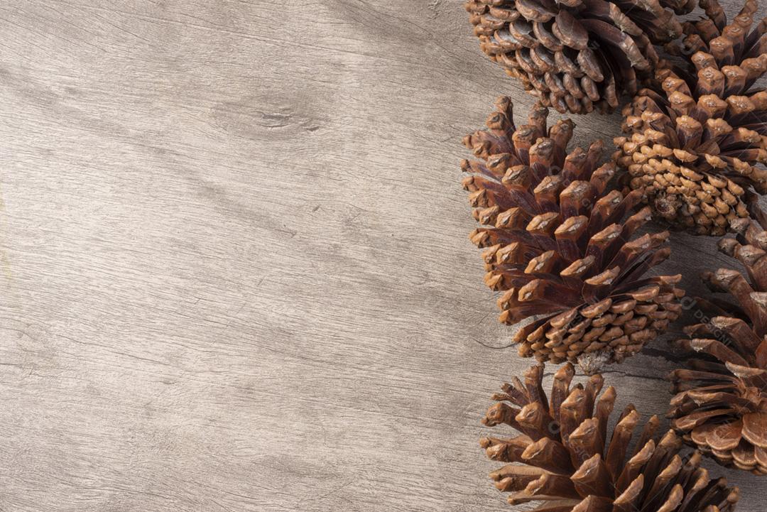 Grupo de pinhas sobre mesa de madeira com espaço de cópia