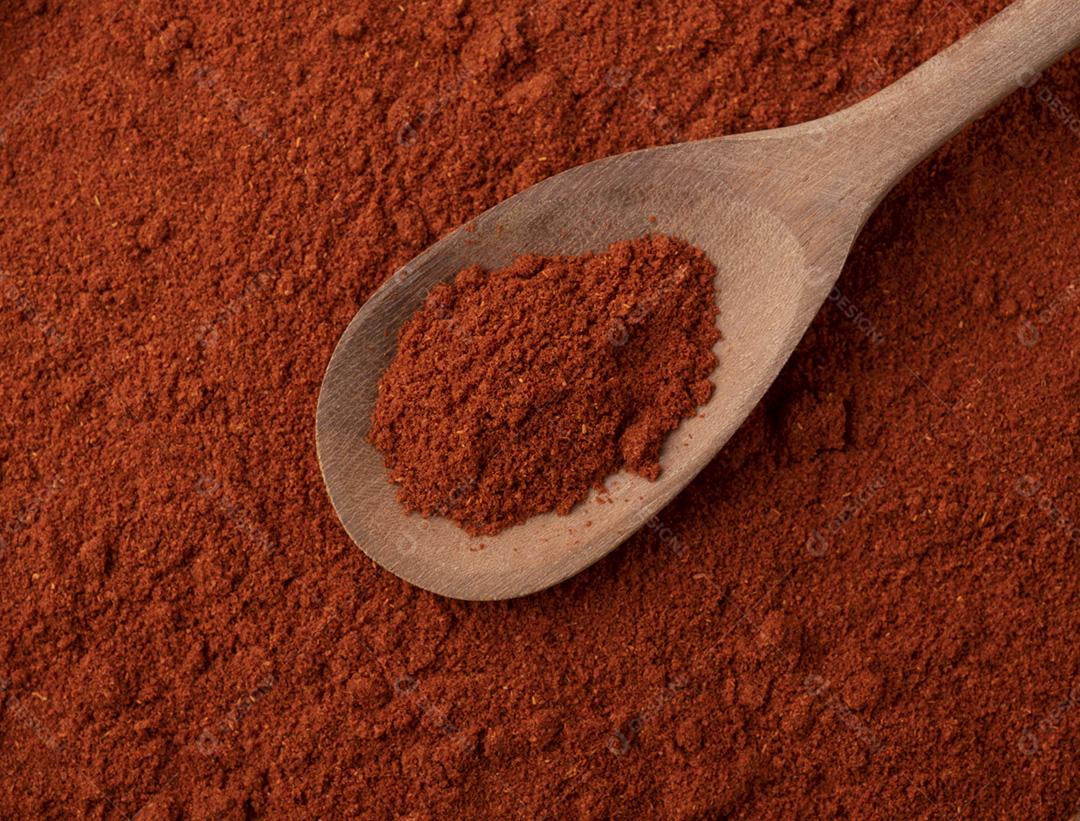 Vista superior, closeup de pimenta páprica vermelha em uma colher de pau