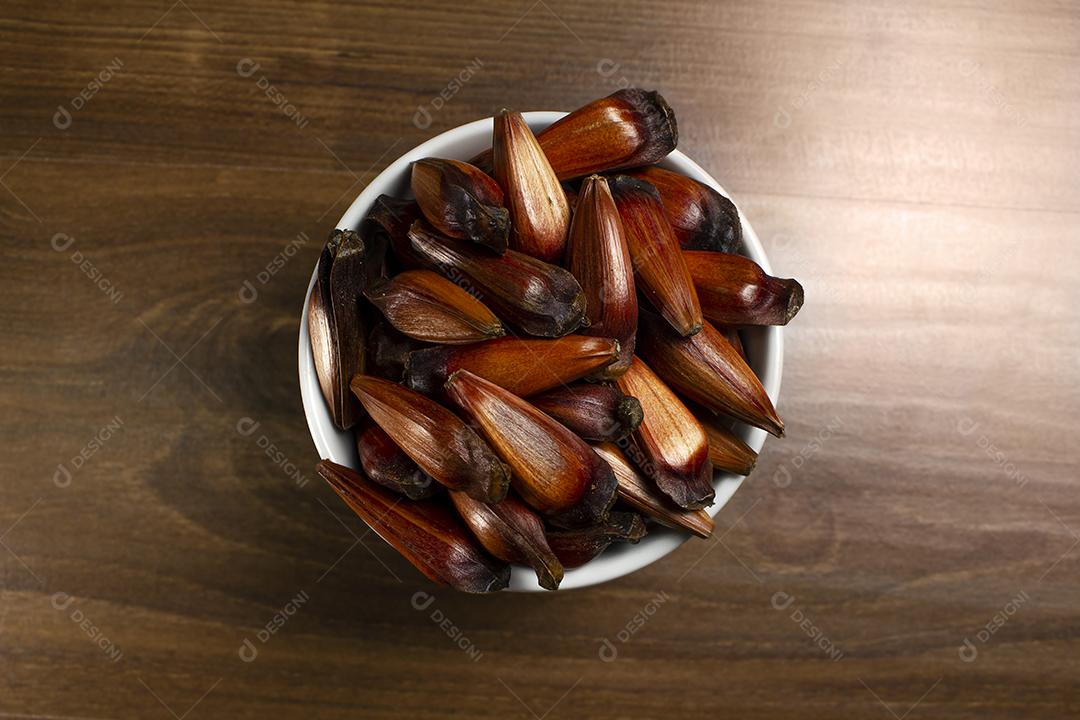 Tigela de pinhões na mesa de madeira