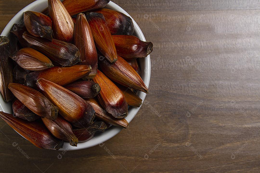 Tigela de pinhões na mesa de madeira