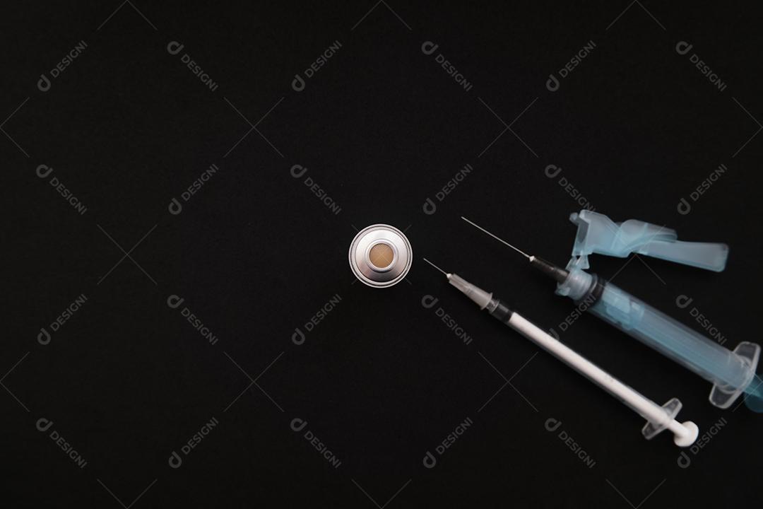 Conjunto de seringas e ampola em fundo preto