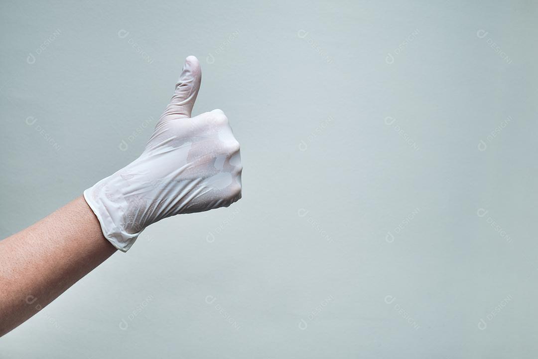 mão com luva fazendo gestos polegares para cima