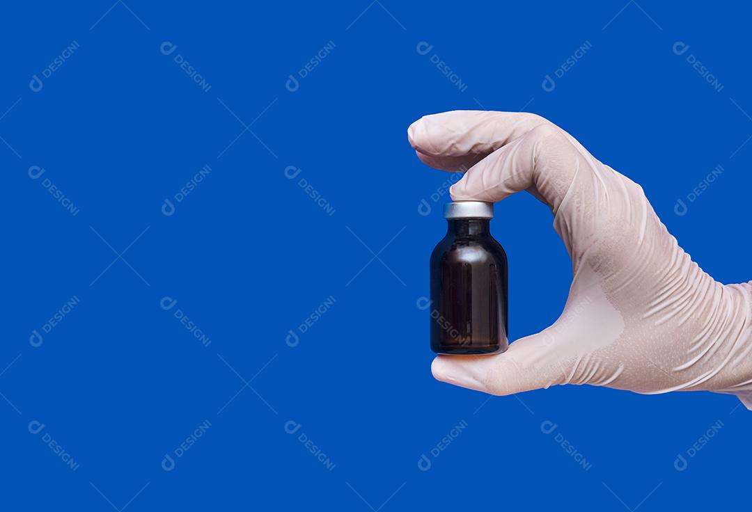 Vista das mãos da enfermeira usando luvas mostrando ampola medicinal.