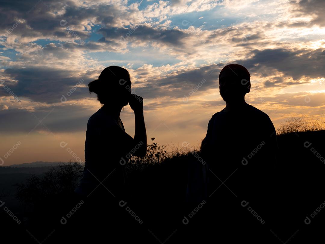 Vista de silhueta de casal em cima da pista de caminhada.