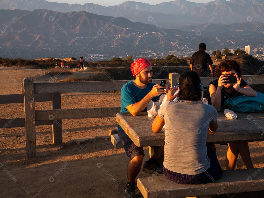 Vista de pessoas assistindo o pôr do sol do Griffith Park em Los Angeles.
