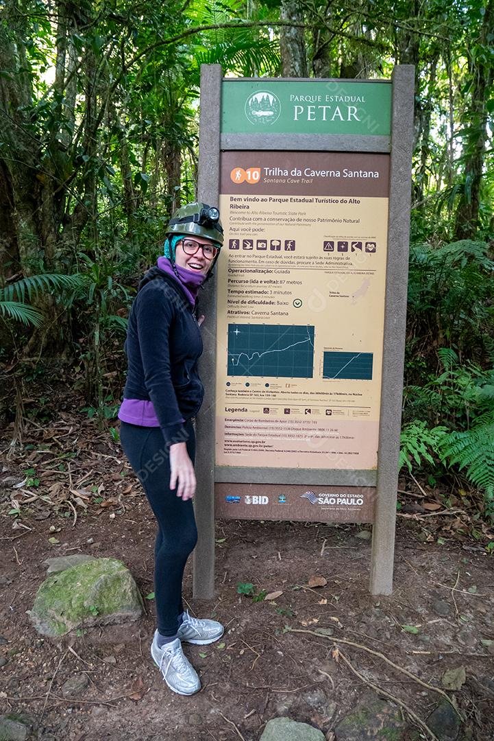 Vista da mulher preparada para trekking apresentando placa.