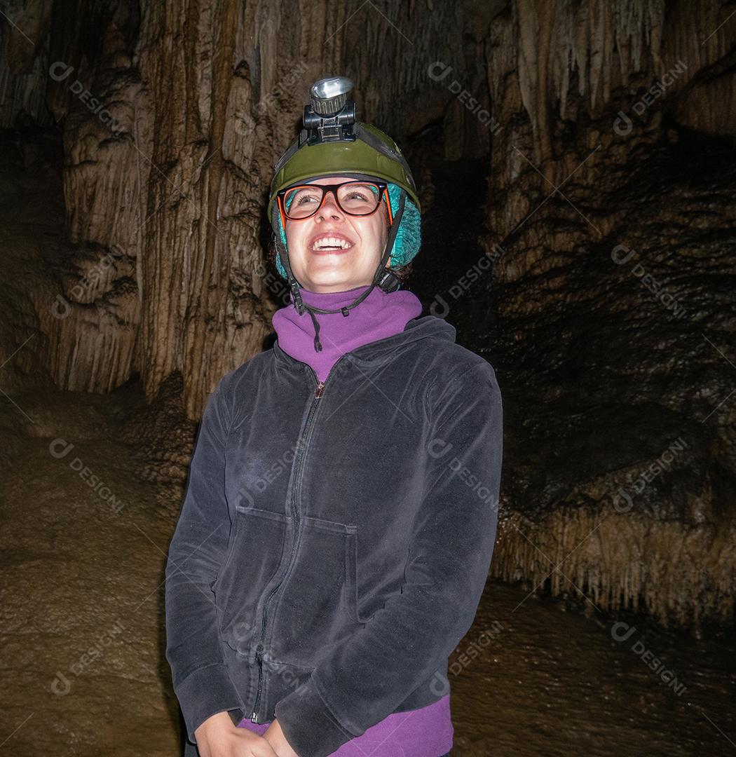 Jovem olhando maravilhada dentro da caverna.