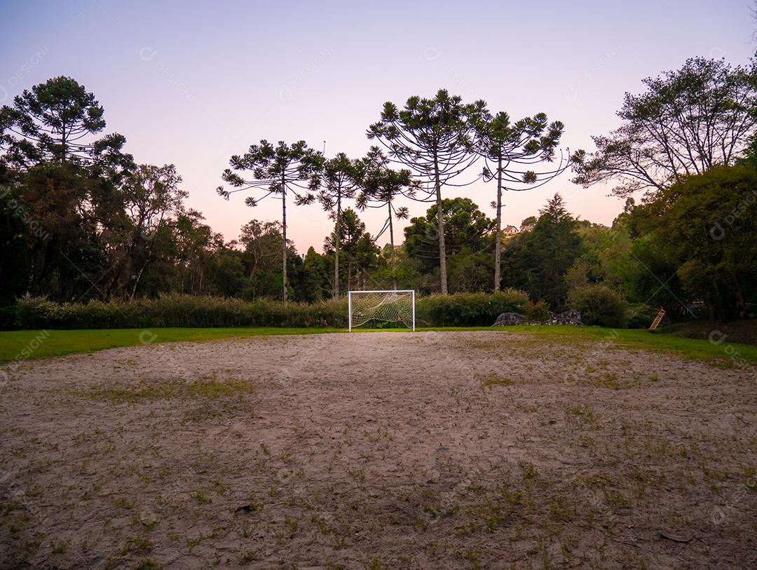 Vista ampla de um campo de futebol brasileiro áspero.