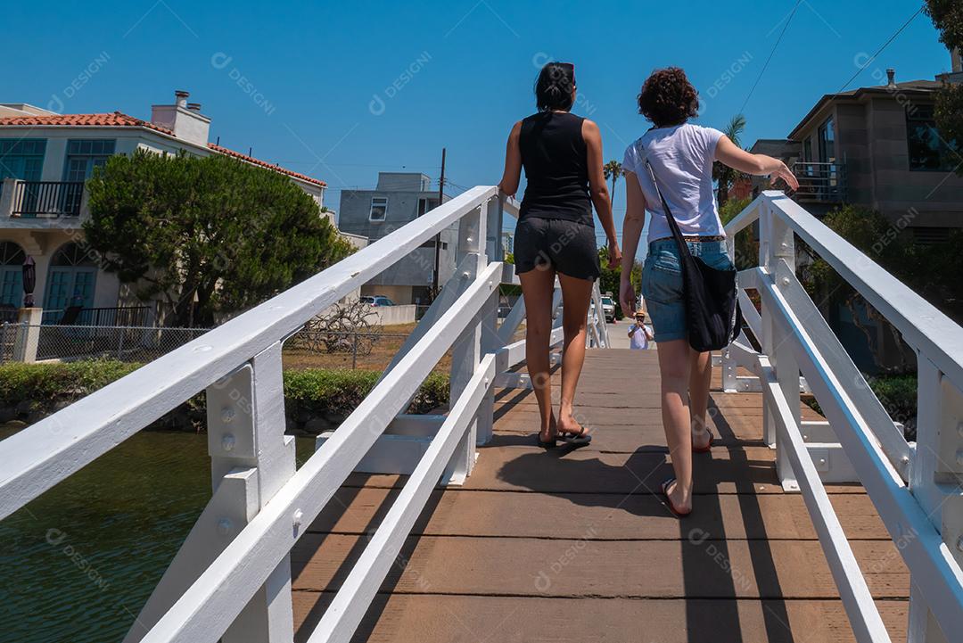 Vista de mulheres jovens passando sobre a ponte sobre os canais de Venice Beach.