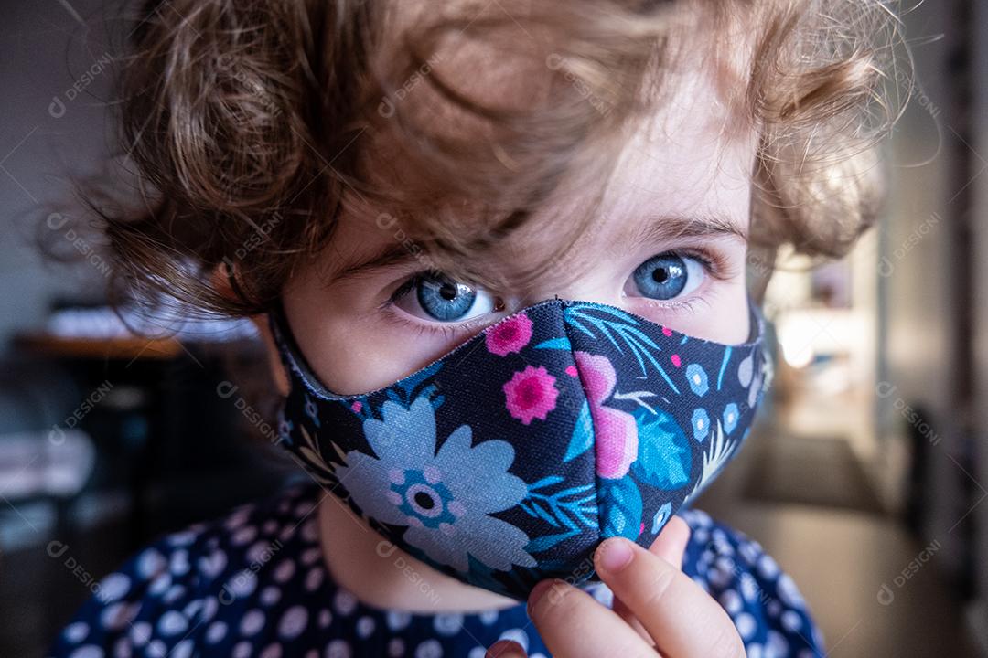 Perto da linda garota de olhos azuis usando máscara.