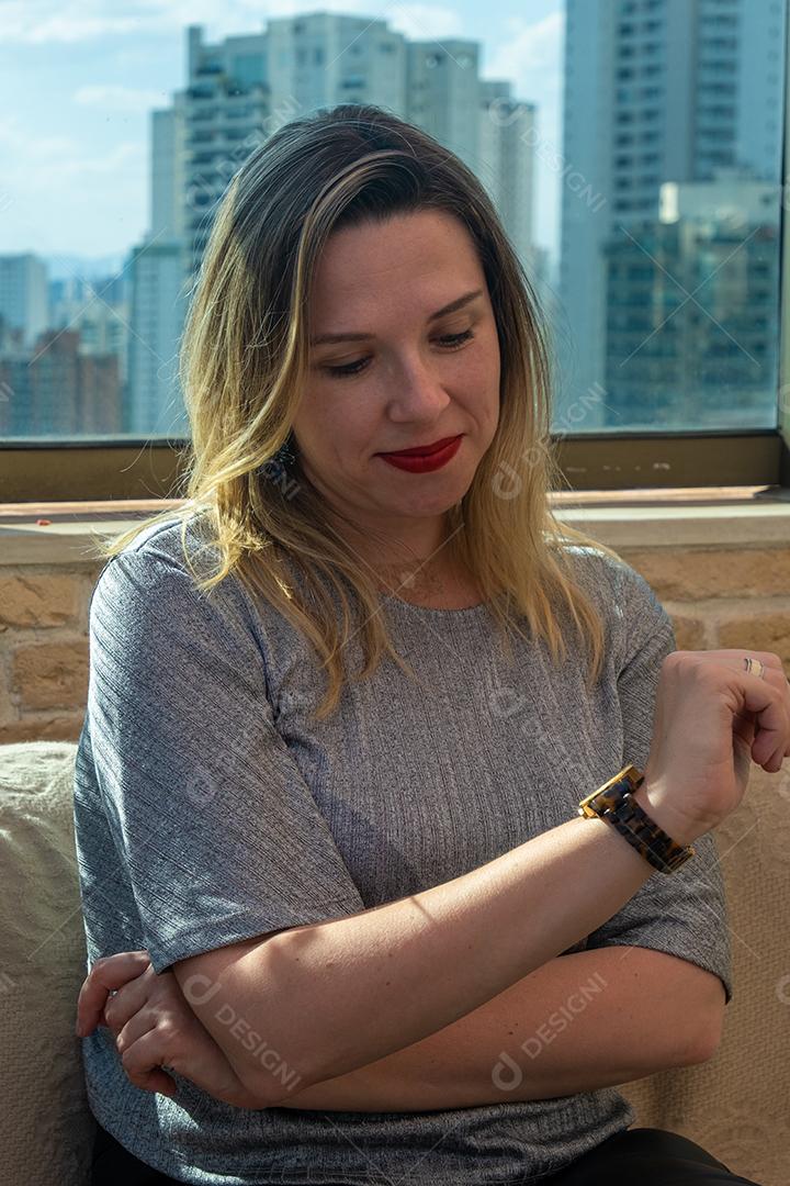 Mulher linda loira olhando a hora em seu relógio