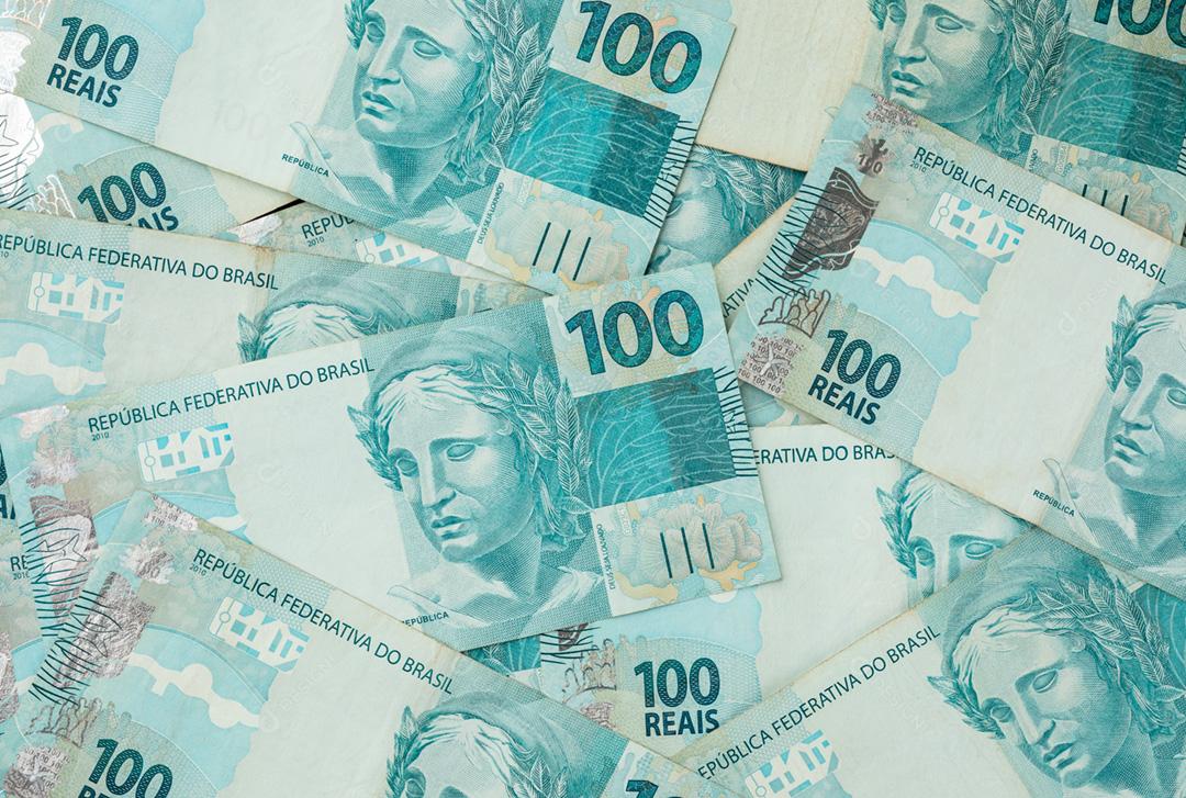 Um groud de notas de cem reais espalhadas