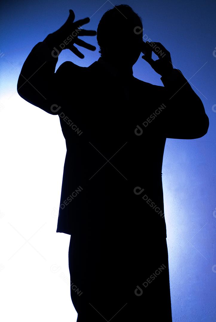 Empresário de terno no celular fazendo um acordo e gesticulando.