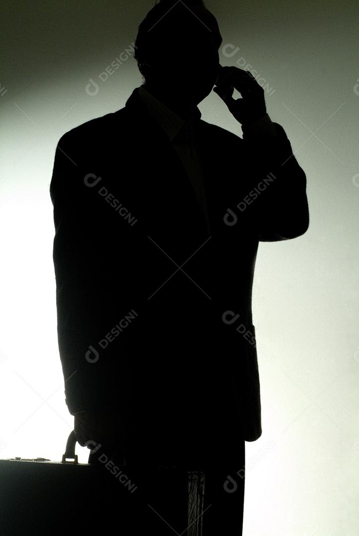 Empresário de terno no celular fazendo um acordo e gesticulando.