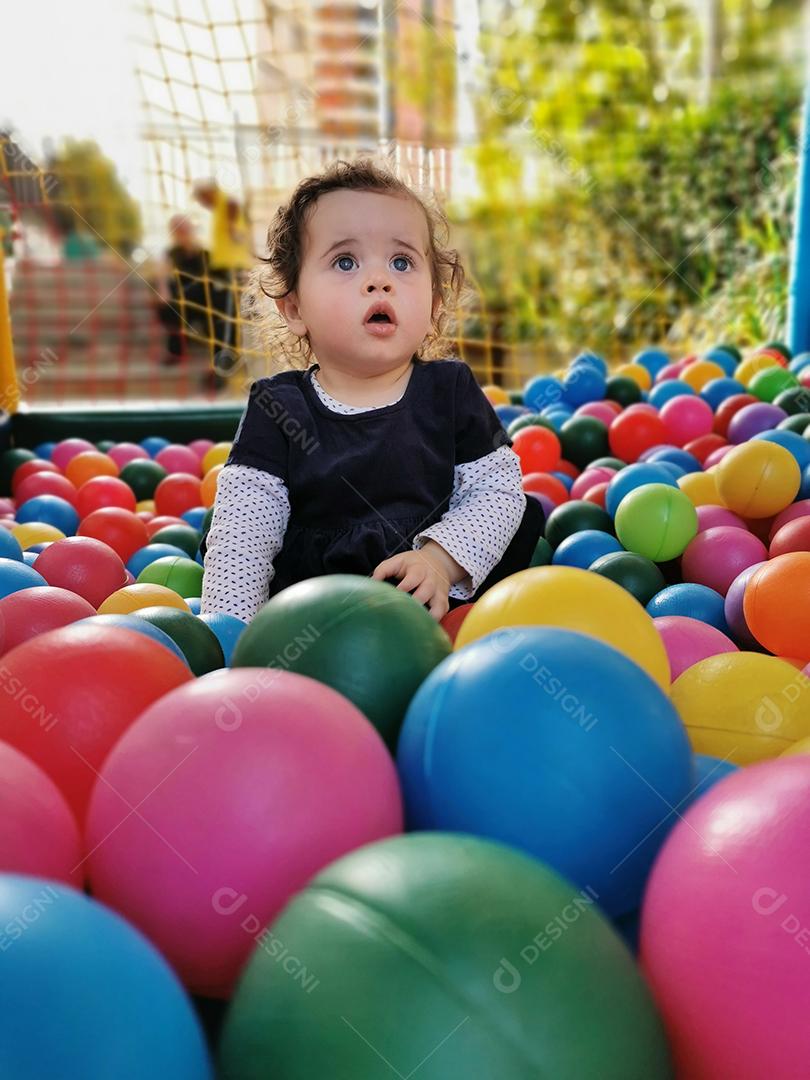 Bebezinho brincando sozinho na piscina de bolinhas.