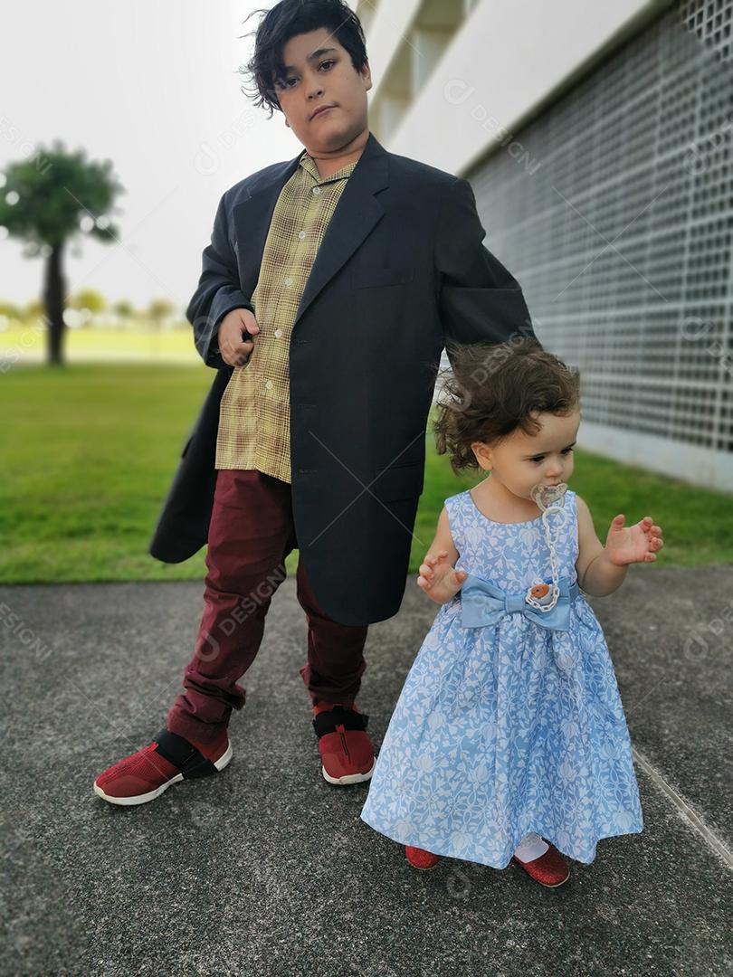 Irmão e irmã bem vestidos para evento social.