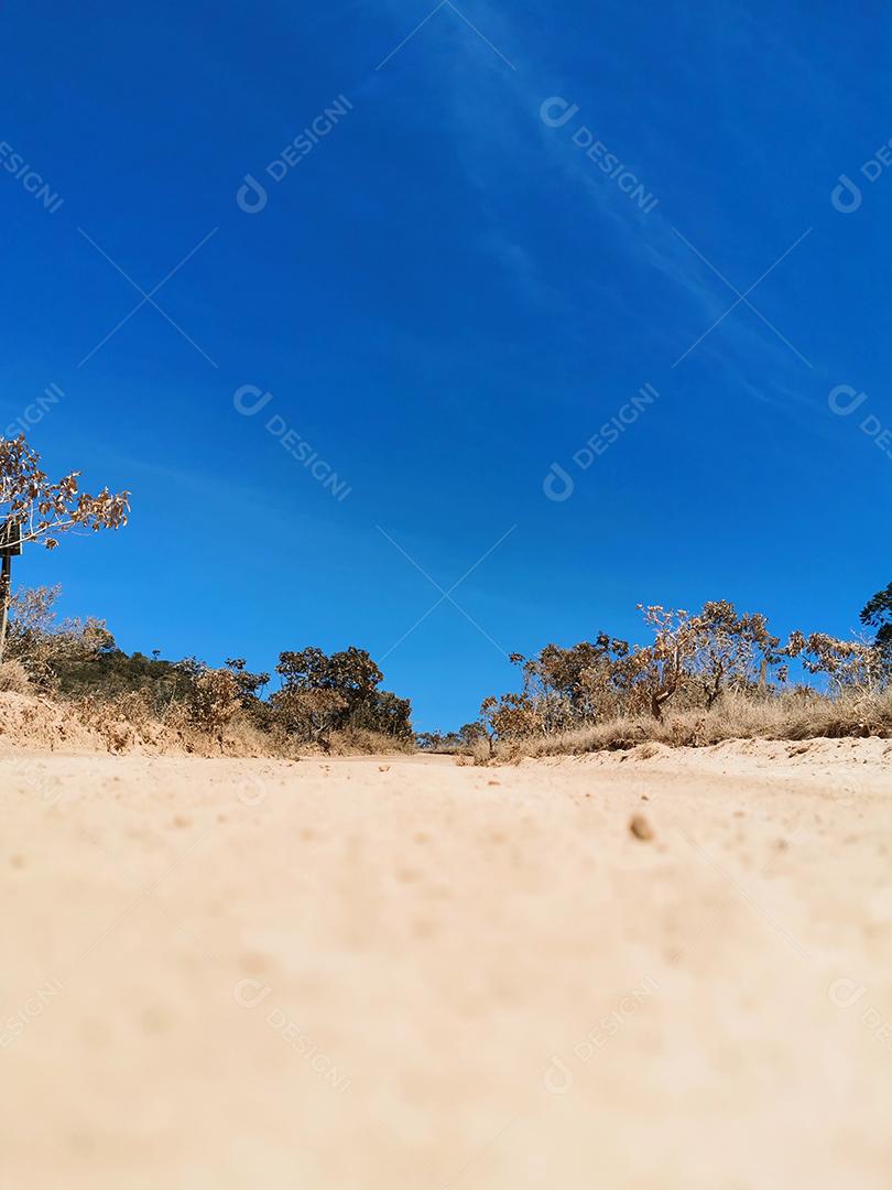 Baixa vista da estrada de terra com céu azul na Chapada dos Veadeiros.