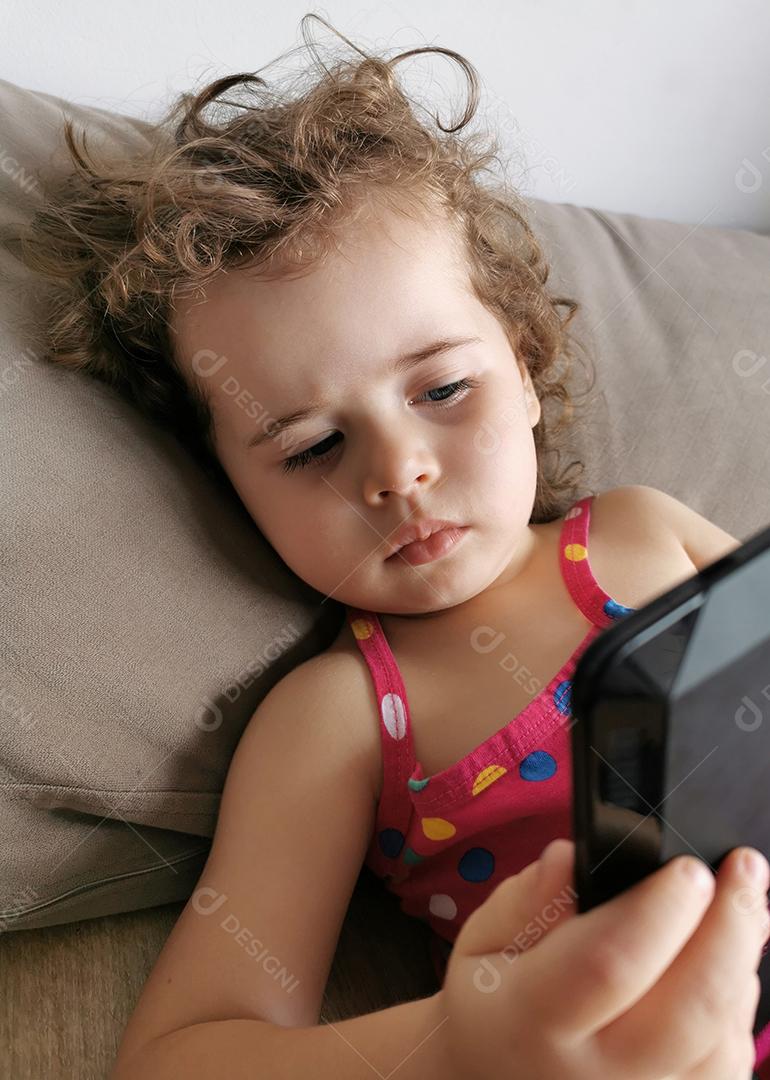 menina bonita usando seu tablet no sofá