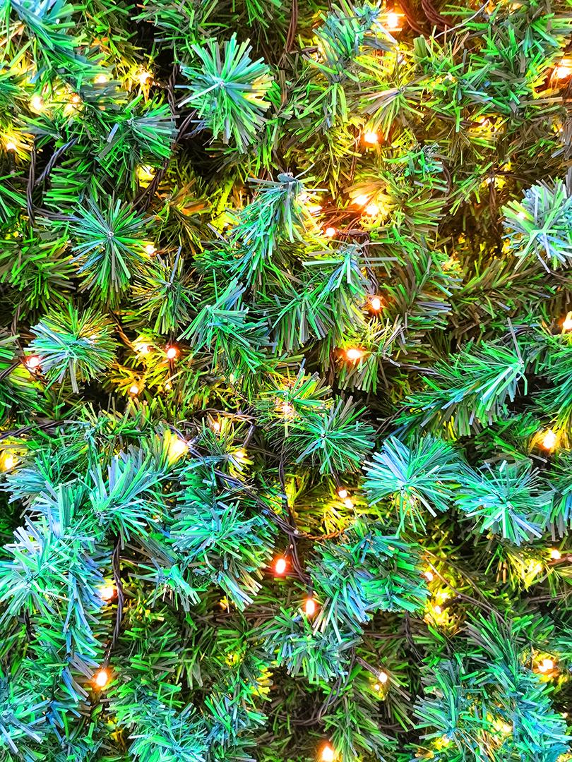 Feche a vista da textura verde da árvore de Natal com enfeites.