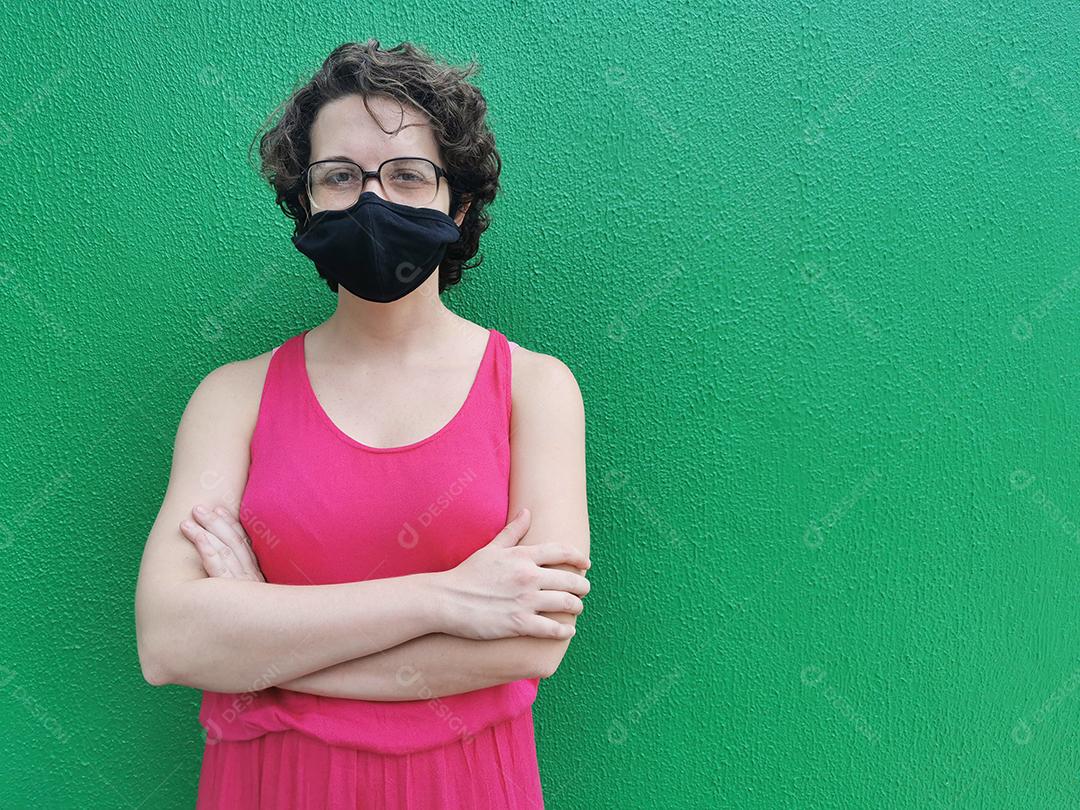 Linda mulher brasileira usando máscara protetora em fundo verde