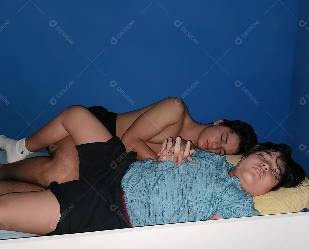 Irmãos brasileiros dormindo juntos em uma cama de solteiro.