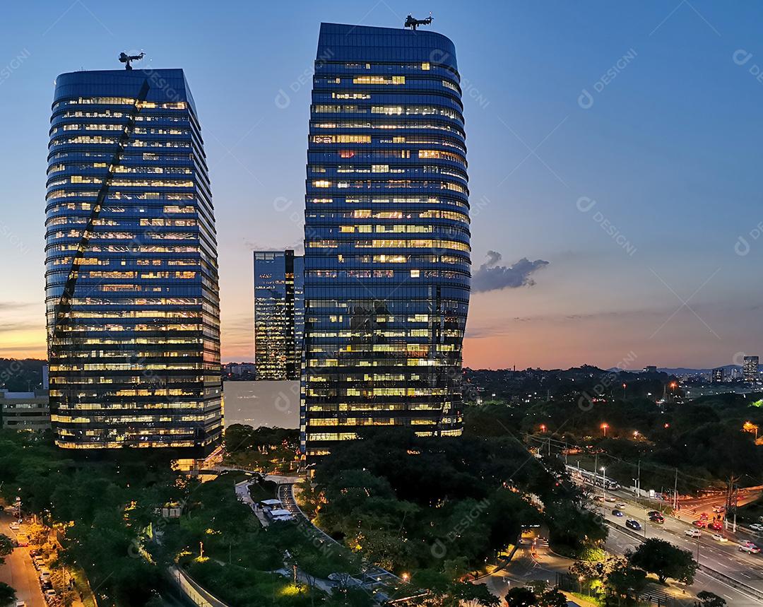 Vista do São Paulo Corporate Towers ao entardecer com as luzes acesas.