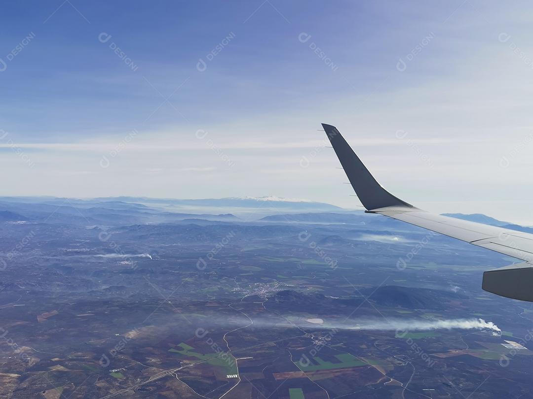 Vista aérea de montanhas e hélices de energia eólica.