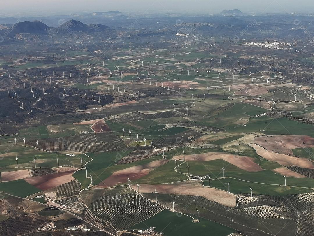 Vista aérea de montanhas e hélices de energia eólica.