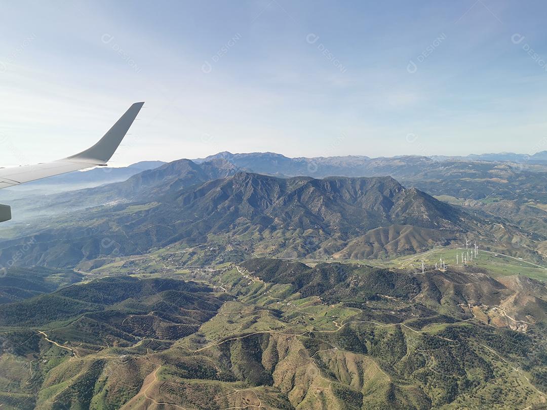 Vista aérea de montanhas e hélices de energia eólica.