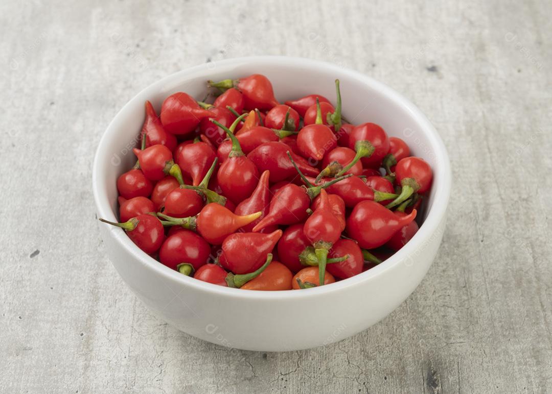 Biquinho de pimenta vermelha em uma tigela sobre a mesa de madeira