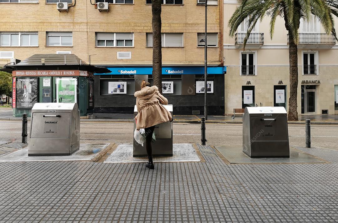 Málaga, Espanha - 22 de fevereiro de 2021: Vista de mulher usando o pé para abrir lixo em pandemia.