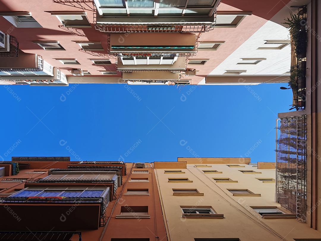 Vista de baixo do céu azul entre edifícios em Málaga.